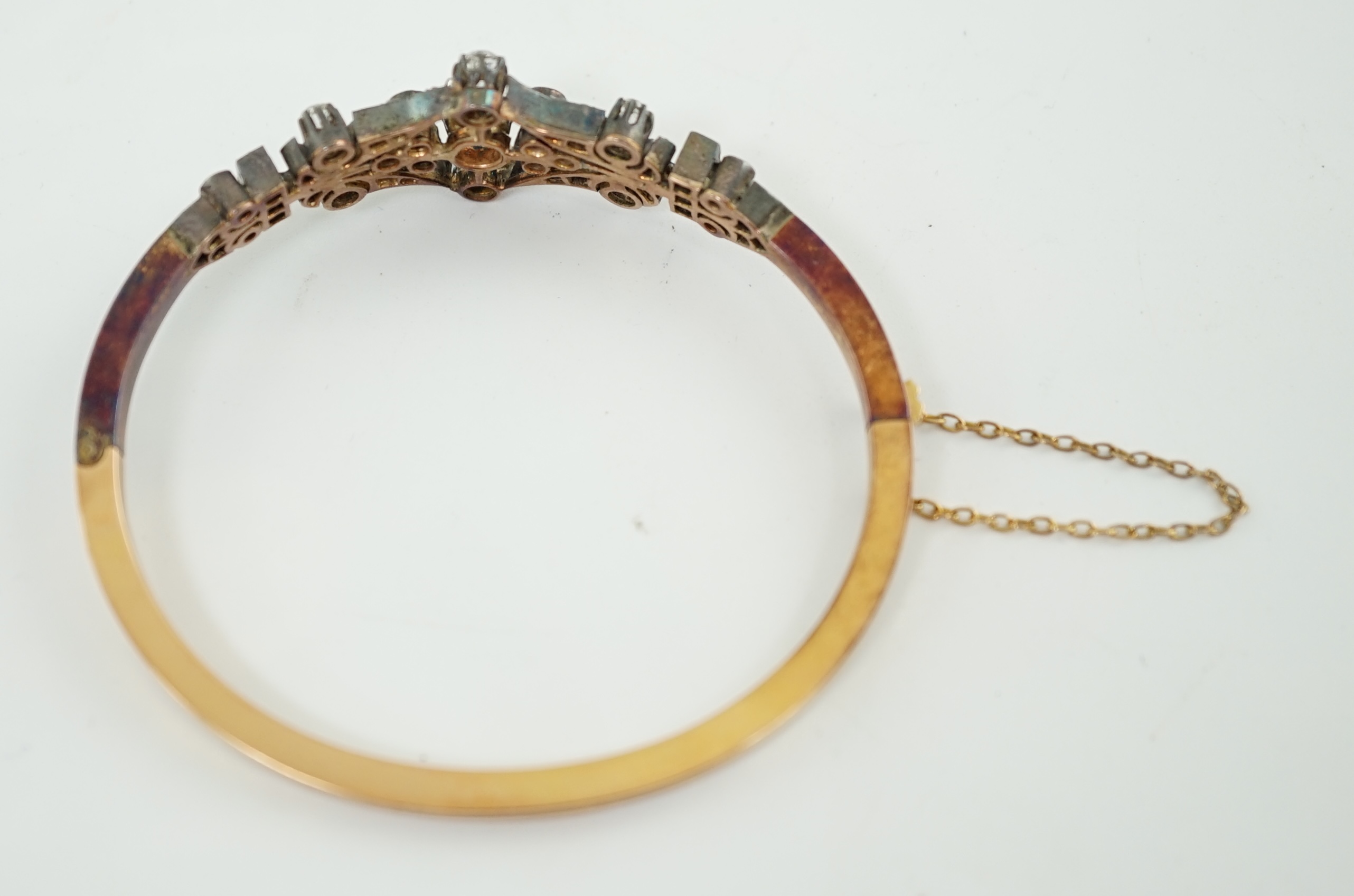 A late 19th/early 20th century French 18ct gold, silver, rose and round cut diamond cluster set hinged bangle